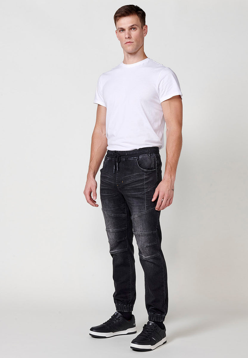 Denim jogger pants with elastic waistband and five pockets with one pocket pocket and details on the knees for men