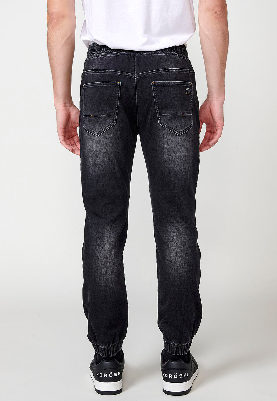 Pantalon de jogging en jean avec taille élastique et cinq poches dont une poche et détails aux genoux pour homme