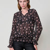 Blouse femme semi-transparente à imprimé mini fleuri, col rond avec volant, encolure en V et manches longues avec poignets caoutchoutés.