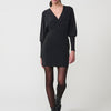 Abito corto da donna con tessuto elastico lucido, maniche lunghe a sbuffo, scollo incrociato e logo Koröshi metallico. Fodera interna.