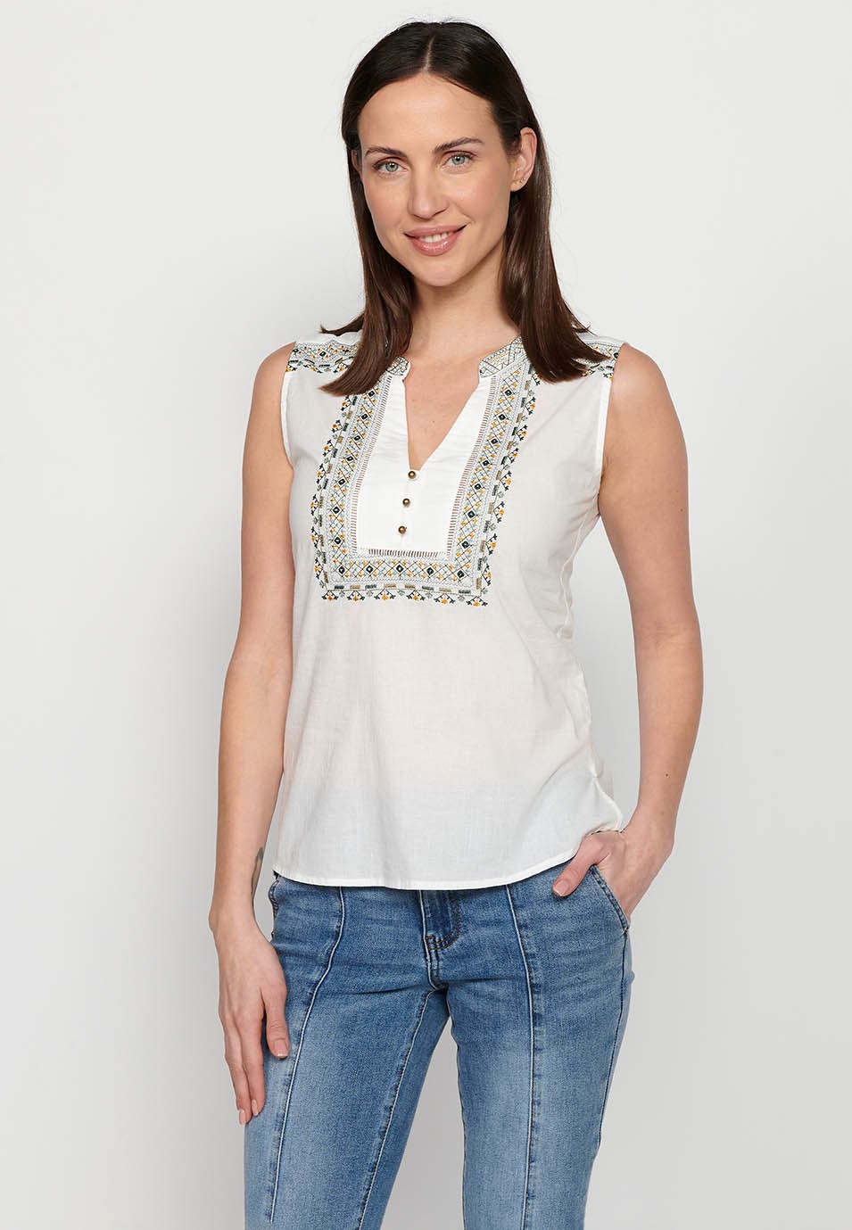 Sleeveless blouse. Embroidered round neckline with opening, white color for women