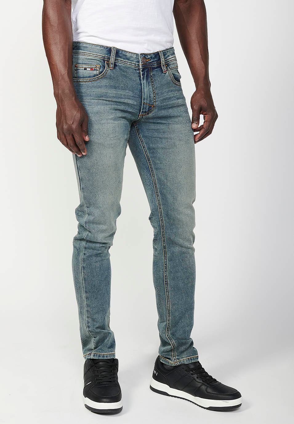 Pantalon long coupe slim avec cinq poches, une poche avec fermeture sur le devant avec fermeture éclair et bouton en Bleu pour Homme