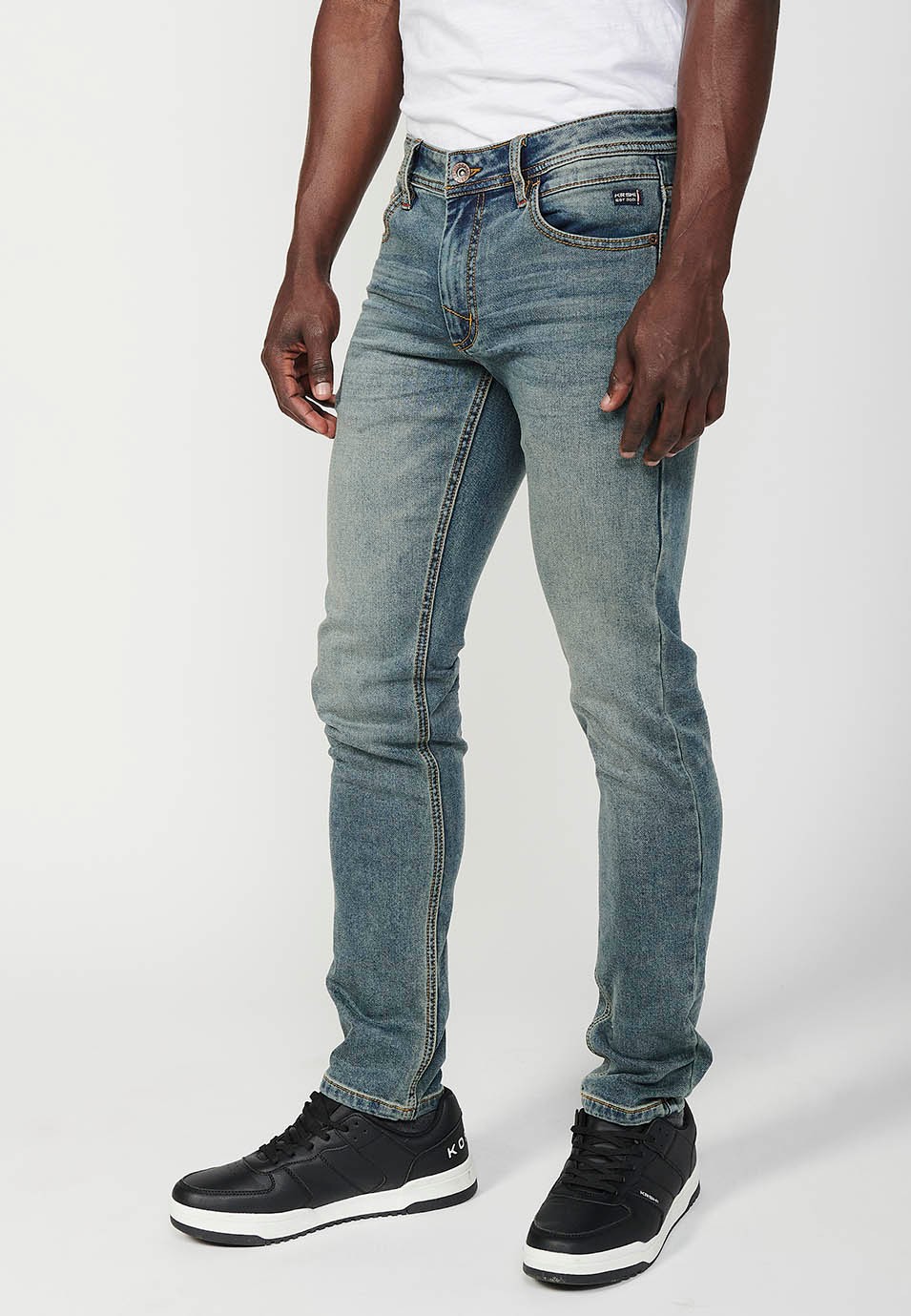 Pantalon long coupe slim avec cinq poches, une poche avec fermeture sur le devant avec fermeture éclair et bouton en Bleu pour Homme