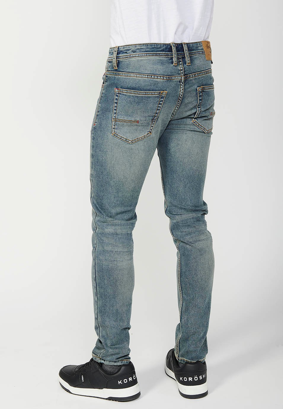 Pantalon long coupe slim avec cinq poches, une poche avec fermeture sur le devant avec fermeture éclair et bouton en Bleu pour Homme