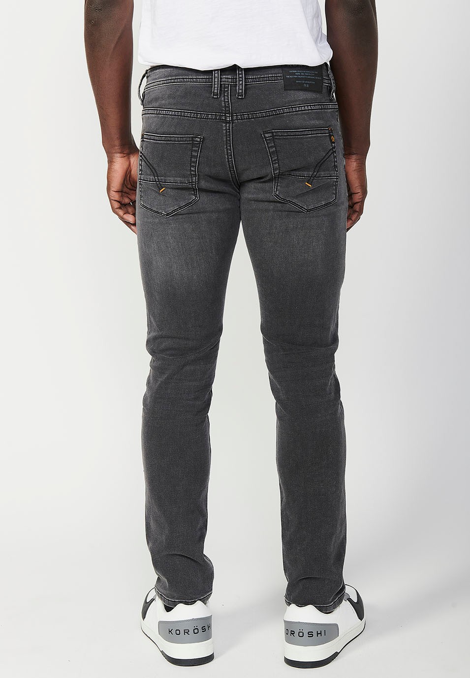 Pantalon long en denim coupe slim avec fermeture éclair sur le devant et fermeture boutonnée et avec poches noires pour homme