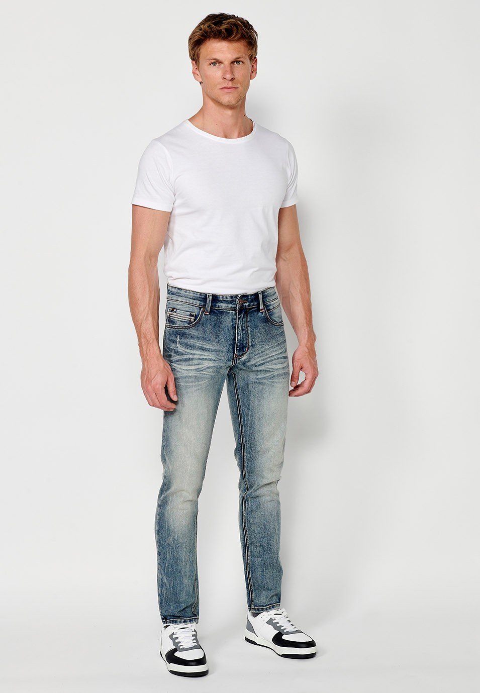 Pantalon long droit en denim coupe classique avec cinq poches, une poche ticket et fermeture avant avec fermeture éclair et bouton en Bleu pour Homme