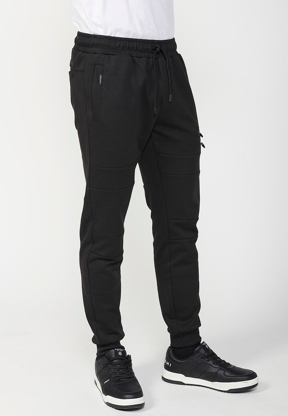 Pantalon de jogging long avec taille caoutchoutée et poches avec coutures aux genoux pour homme en noir 1