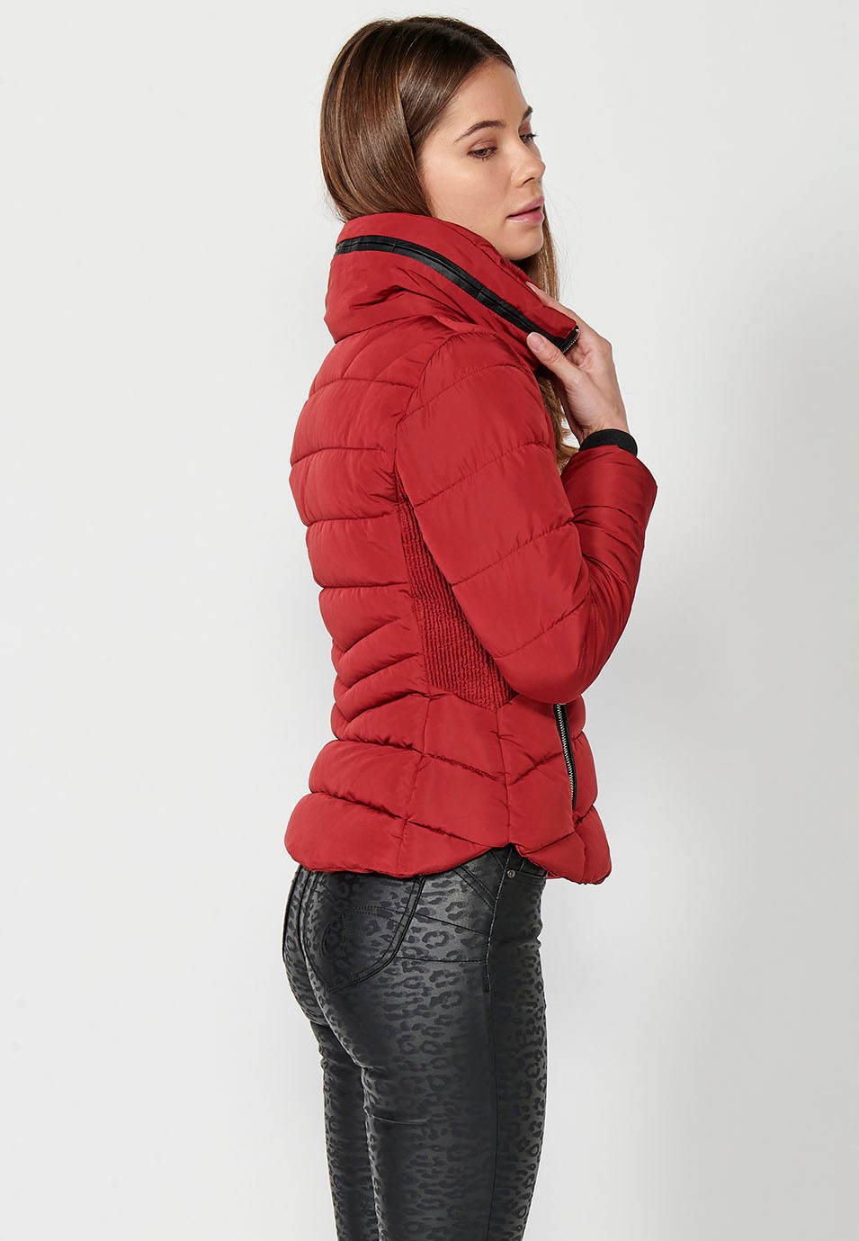 Parka acolchada corta con cuello alto y cierre delantero con cremallera y bolsillos de color rojo para mujer.