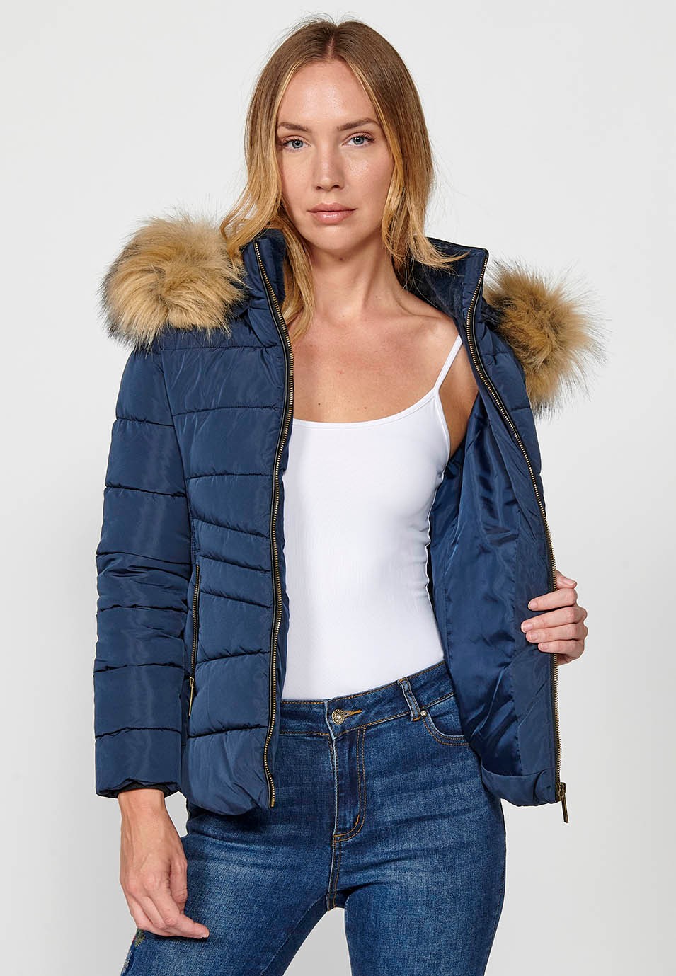 Veste matelassée avec col en fausse fourrure et capuche avec fermeture sur le devant et fermeture éclair pour femme en bleu marine 1