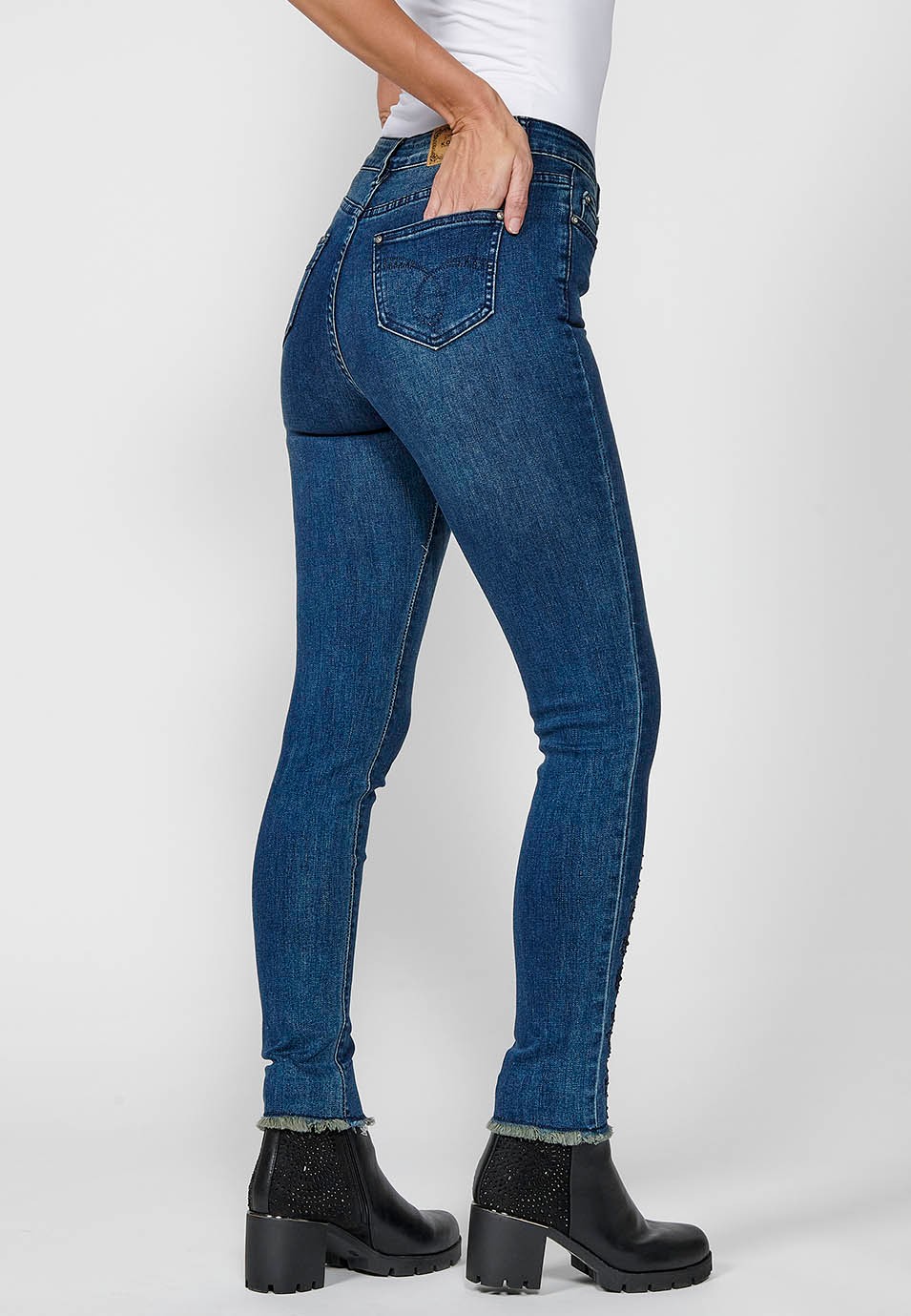 Pantalón largo denim slim cropped con cinco bolsillos y cierre delantero con cremallera y botón con detalles bordados florales para mujer de color azul