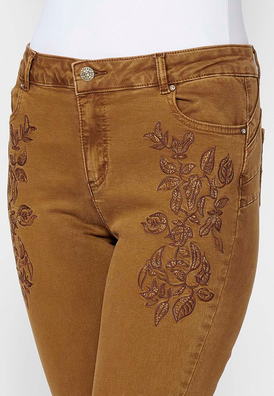 Slim fit long trousers with embroidered details and front zip and button closure for women in ochre 6