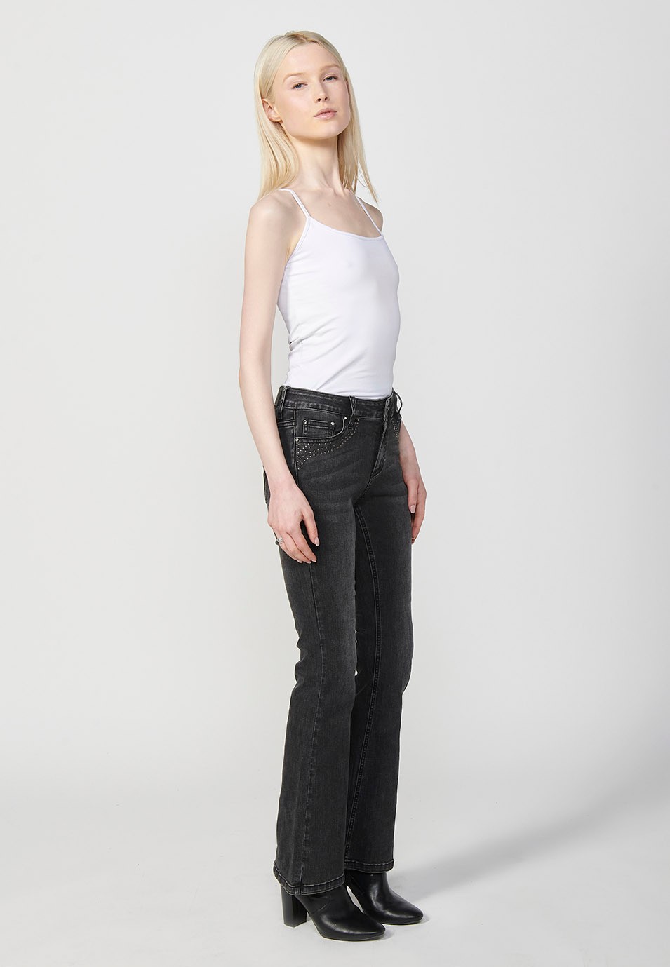 Pantalon en denim boot cut à cinq poches, évasé, couleur noire, avec applications métalliques sur les poches pour Femme