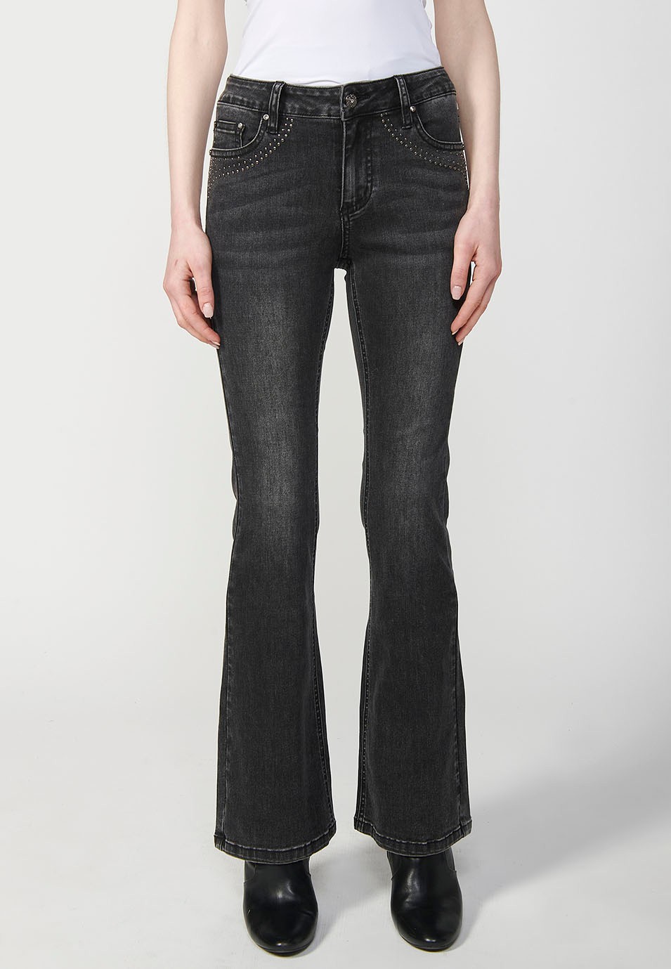 Pantalon en denim boot cut à cinq poches, évasé, couleur noire, avec applications métalliques sur les poches pour Femme