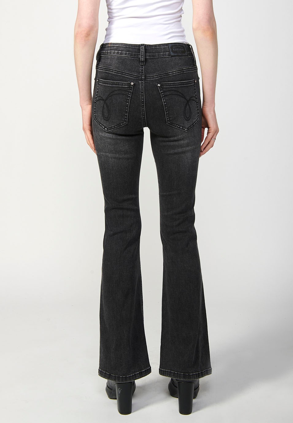 Pantalon en denim boot cut à cinq poches, évasé, couleur noire, avec applications métalliques sur les poches pour Femme