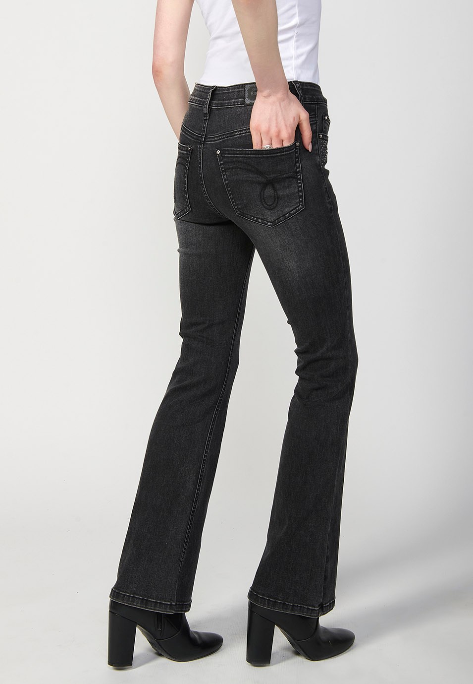 Pantalon en denim boot cut à cinq poches, évasé, couleur noire, avec applications métalliques sur les poches pour Femme