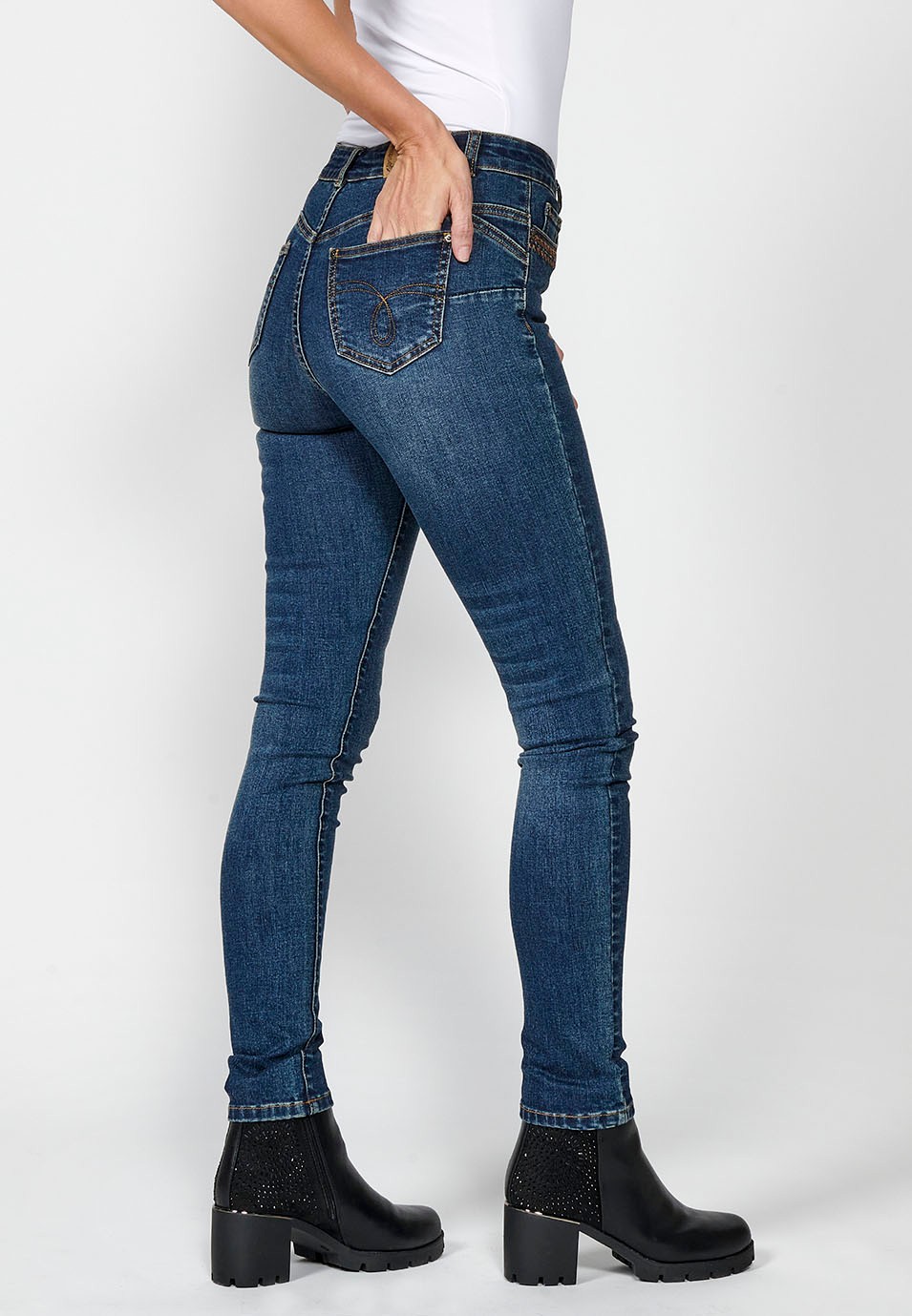 Pantalón denim slim fit cinco bolsillos push up con detalle bordado ocre y aplicaciones metálicas en bolsillos para mujer en color azul