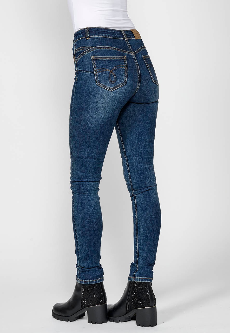 Pantalón denim slim fit cinco bolsillos push up con detalle bordado ocre y aplicaciones metálicas en bolsillos para mujer en color azul