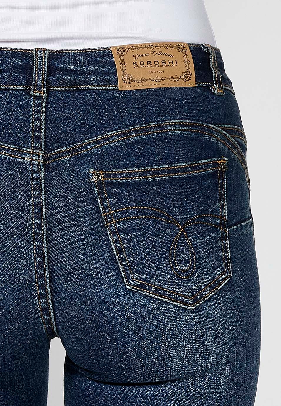 Pantalón denim slim fit cinco bolsillos push up con detalle bordado ocre y aplicaciones metálicas en bolsillos para mujer en color azul