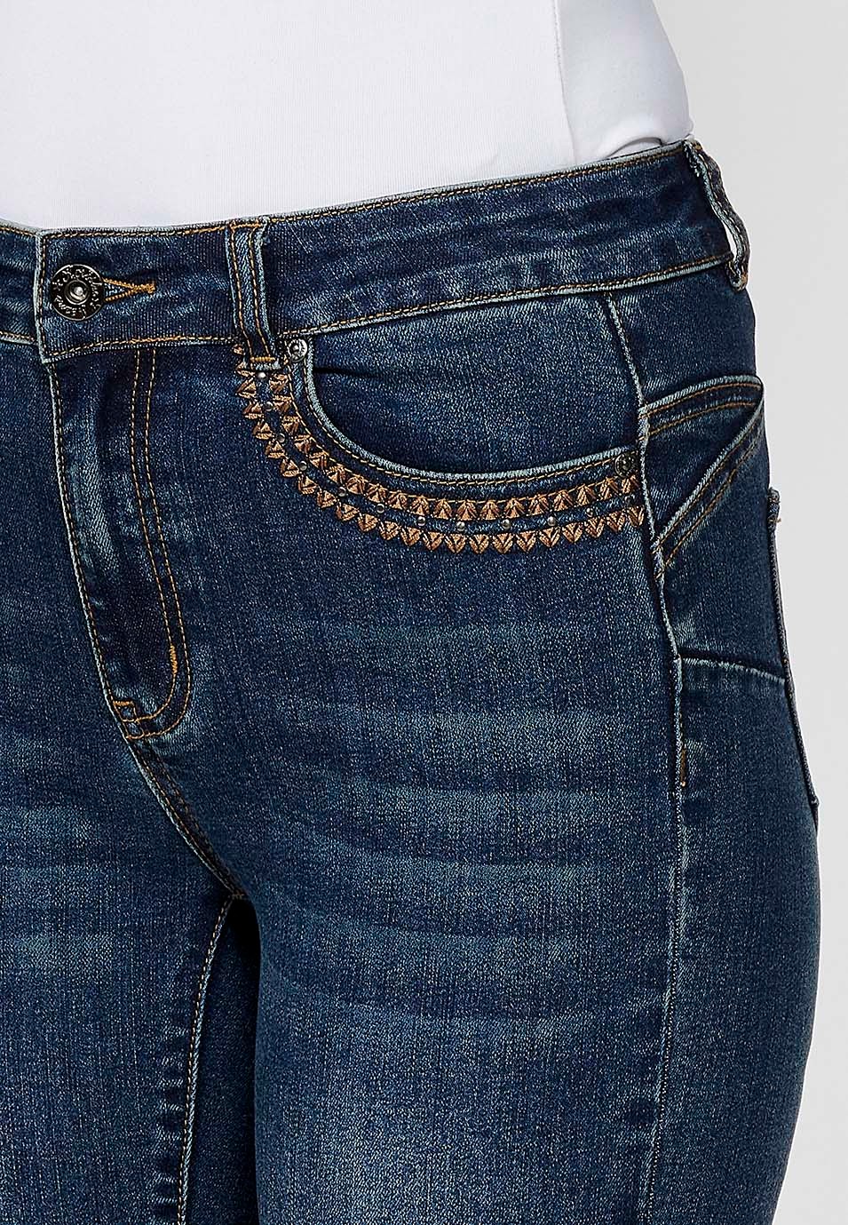 Pantalón denim slim fit cinco bolsillos push up con detalle bordado ocre y aplicaciones metálicas en bolsillos para mujer en color azul