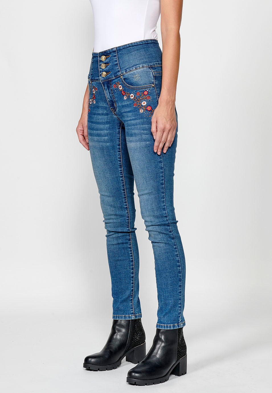 Pantalón denim push up cinco bolsillos y cintura fajín con bordado de flores y brillantes en bolsillos para mujer de color azul