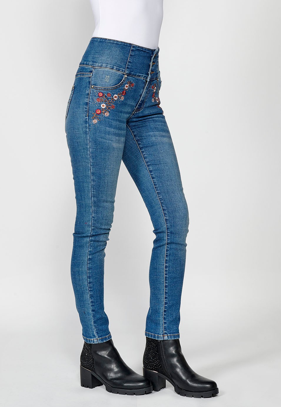 Pantalón denim push up cinco bolsillos y cintura fajín con bordado de flores y brillantes en bolsillos para mujer de color azul