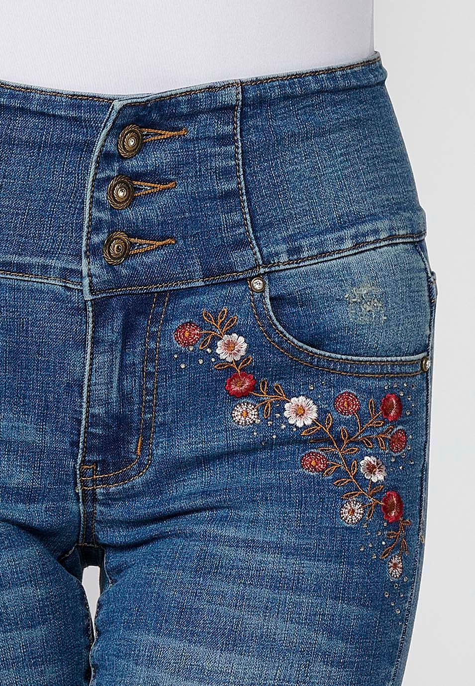 Pantalón denim push up cinco bolsillos y cintura fajín con bordado de flores y brillantes en bolsillos para mujer de color azul