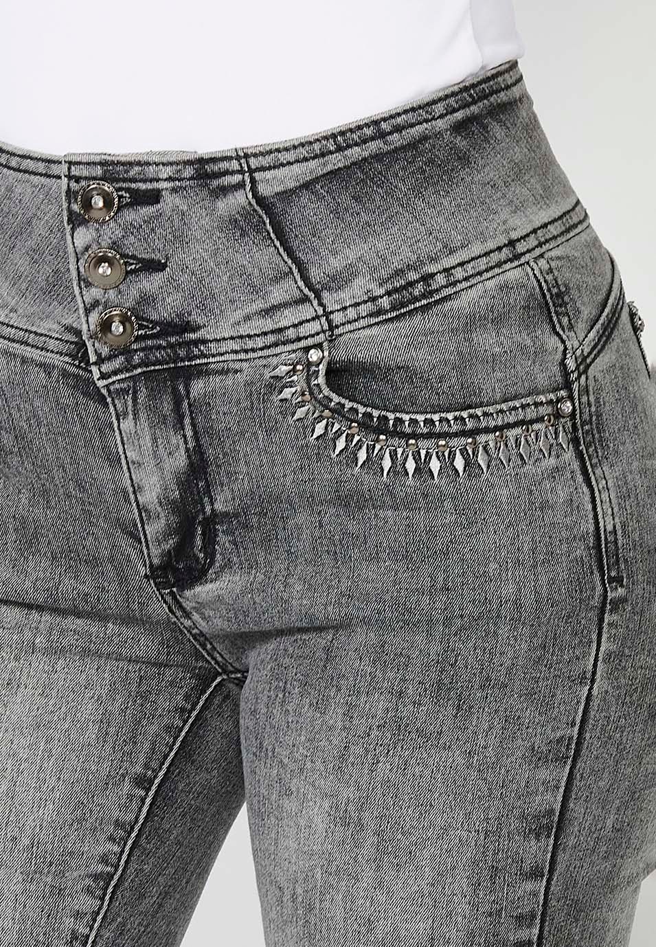 Pantalon push-up en jean coupe slim avec cinq poches et ceinture à la taille avec détails brodés et applications métalliques pour femme en gris