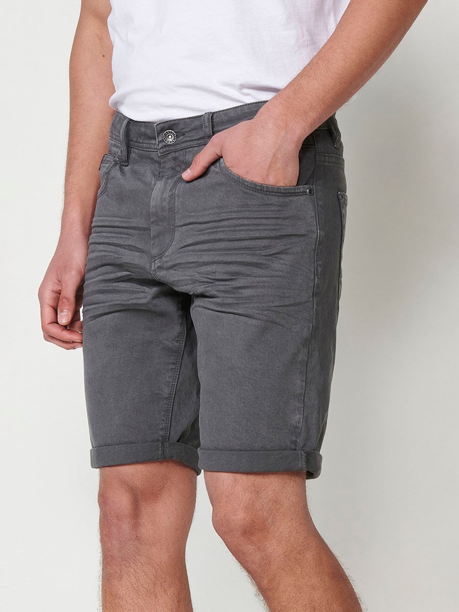 Bermuda regular fit con cierre frontal con cremallera y botón con cinco bolsillos uno cerillero y bajos con vuelta sin fijar para hombre de color gris.