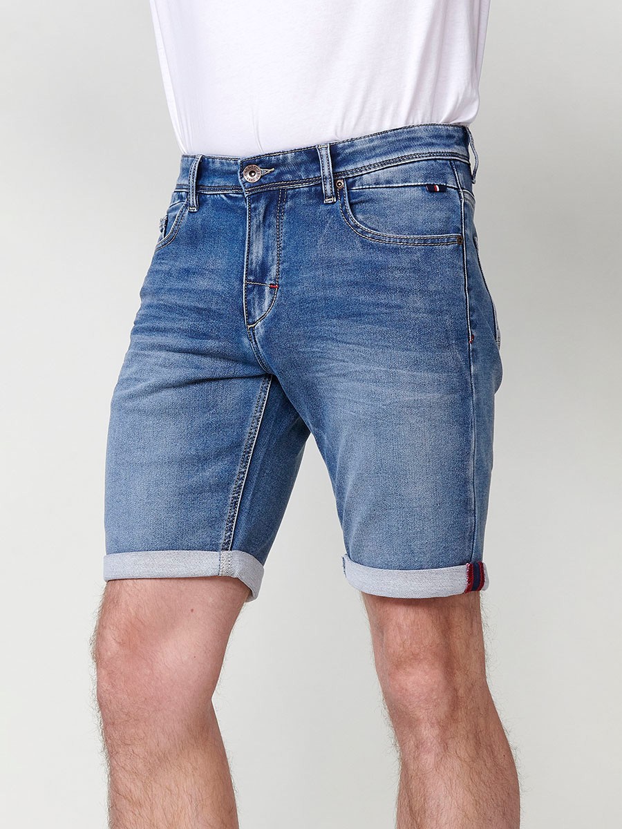 Bermuda denim regular fit con cierre frontal con cremallera y botón con cinco bolsillos efecto desgastado con bajos con vuelta sin fijar para hombre de color azul