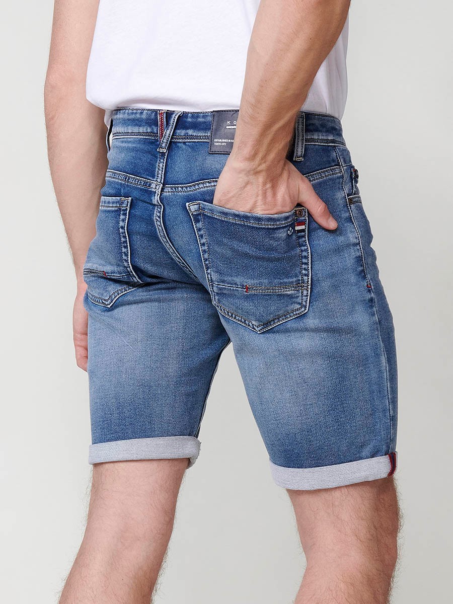 Bermuda denim regular fit con cierre frontal con cremallera y botón con cinco bolsillos efecto desgastado con bajos con vuelta sin fijar para hombre de color azul