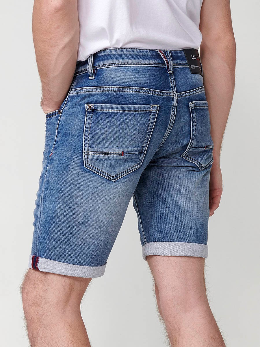 Bermuda denim regular fit con cierre frontal con cremallera y botón con cinco bolsillos efecto desgastado con bajos con vuelta sin fijar para hombre de color azul