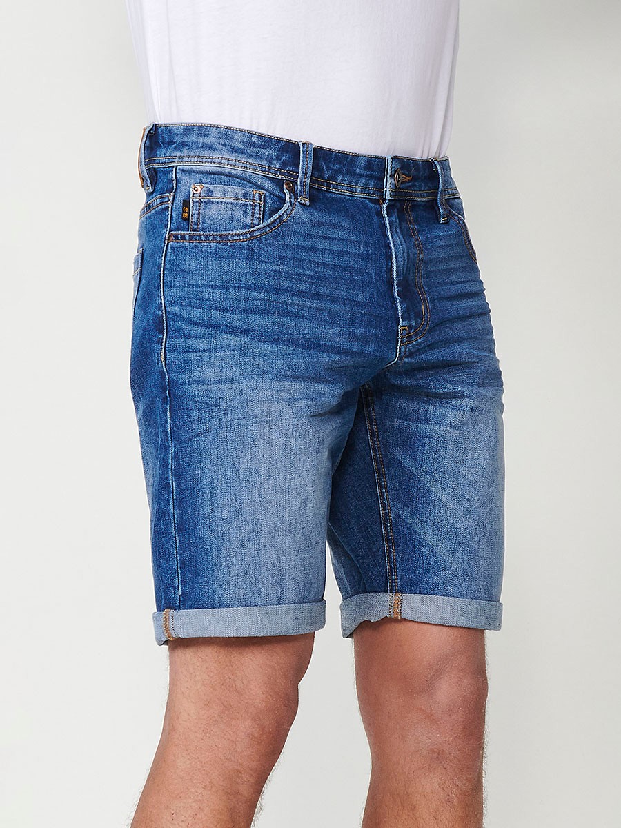 Bermuda denim relaxed fit con cierre frontal con cremallera y botón con cinco bolsillos efecto desgastado con bajos con vuelta sin fijar para hombre de color de azul medio