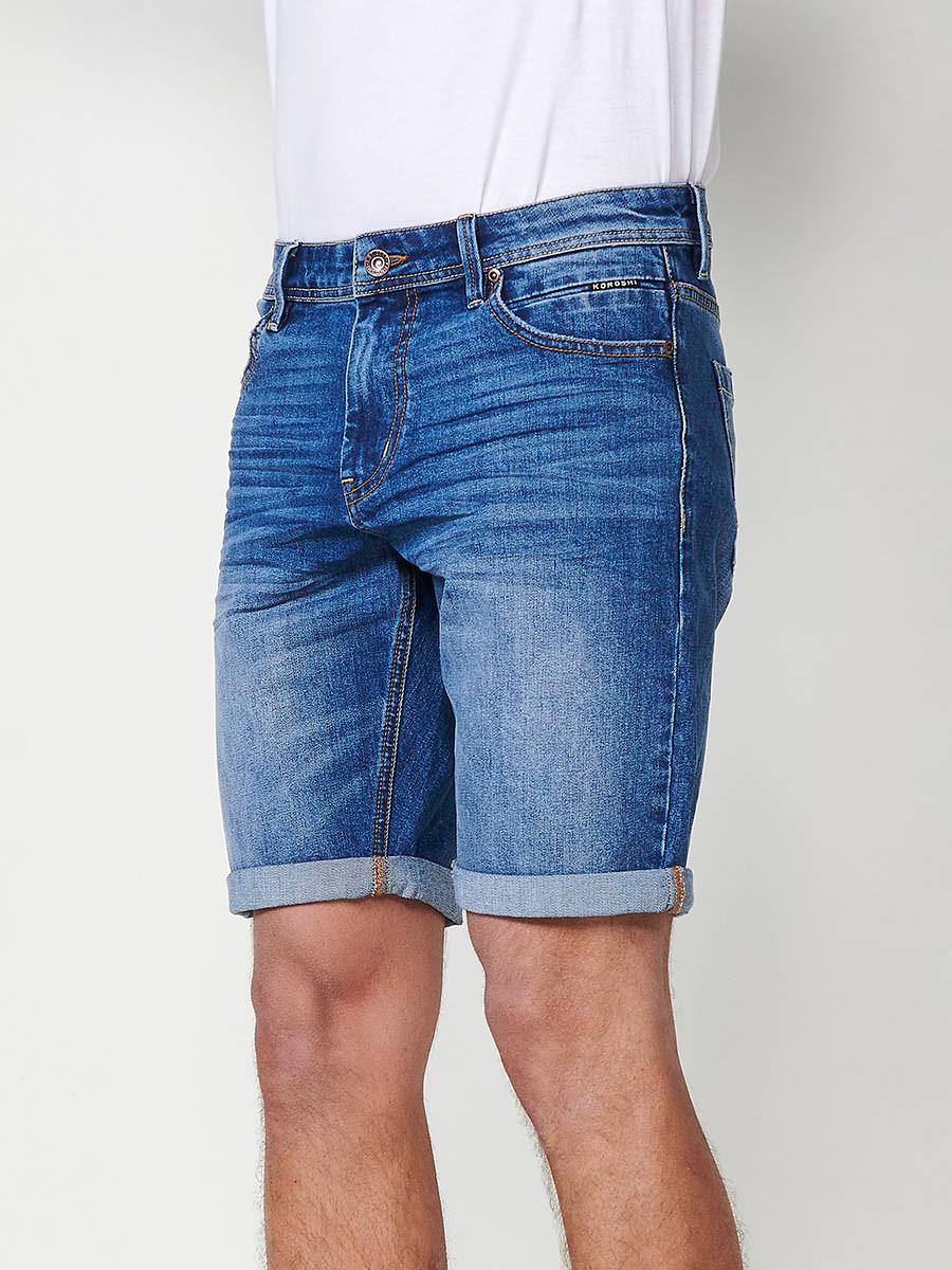 Bermuda denim relaxed fit con cierre frontal con cremallera y botón con cinco bolsillos efecto desgastado con bajos con vuelta sin fijar para hombre de color de azul medio