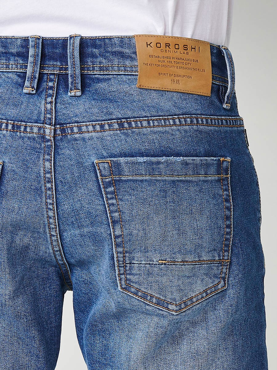 Bermuda denim relaxed fit con cierre frontal con cremallera y botón con cinco bolsillos efecto desgastado con bajos con vuelta sin fijar para hombre de color de azul medio