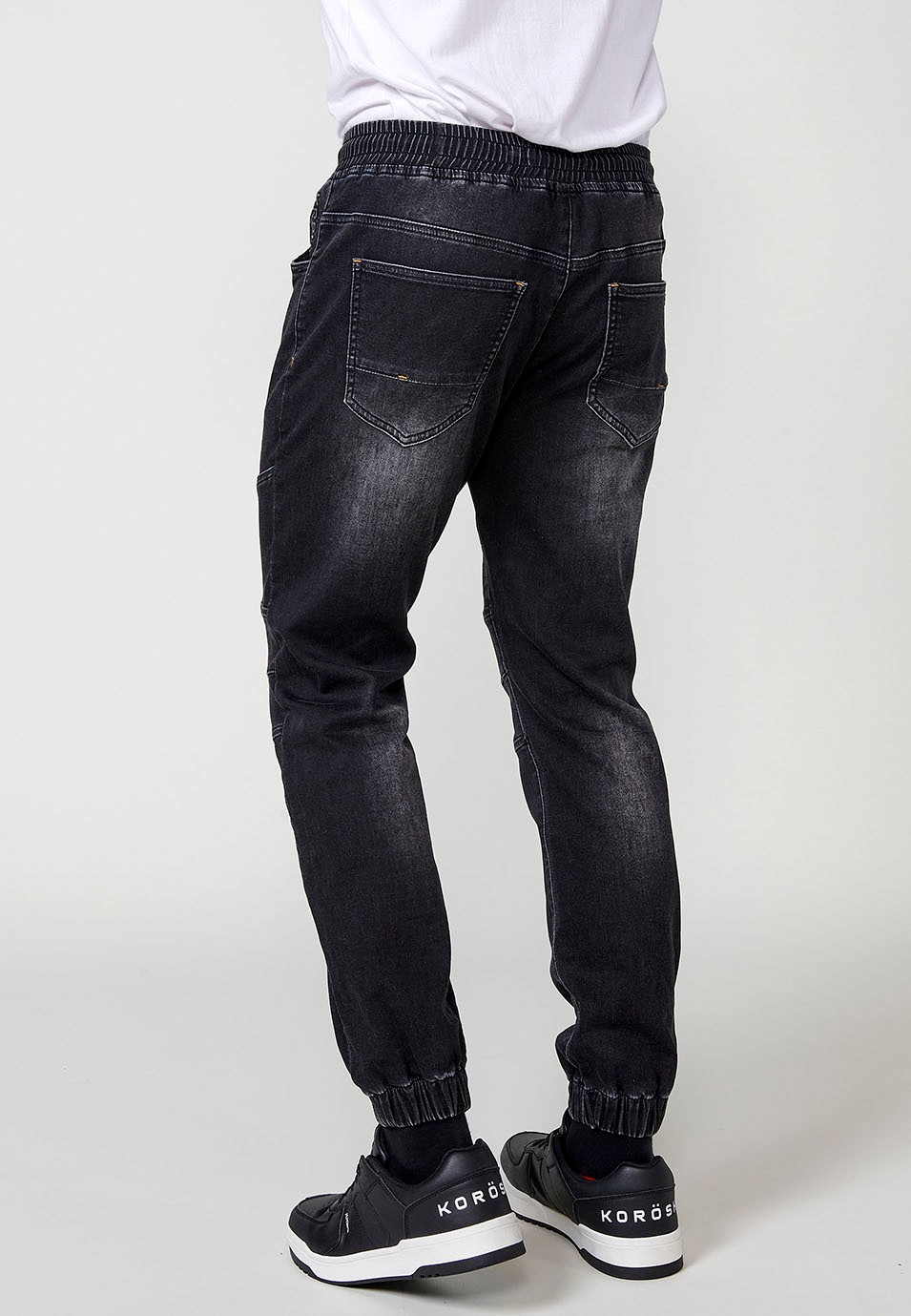 Pantalón jogger denim con Cintura con goma elástica y Cinco bolsillos con uno cerillero con Detalles en las rodillas color Negro para Hombre