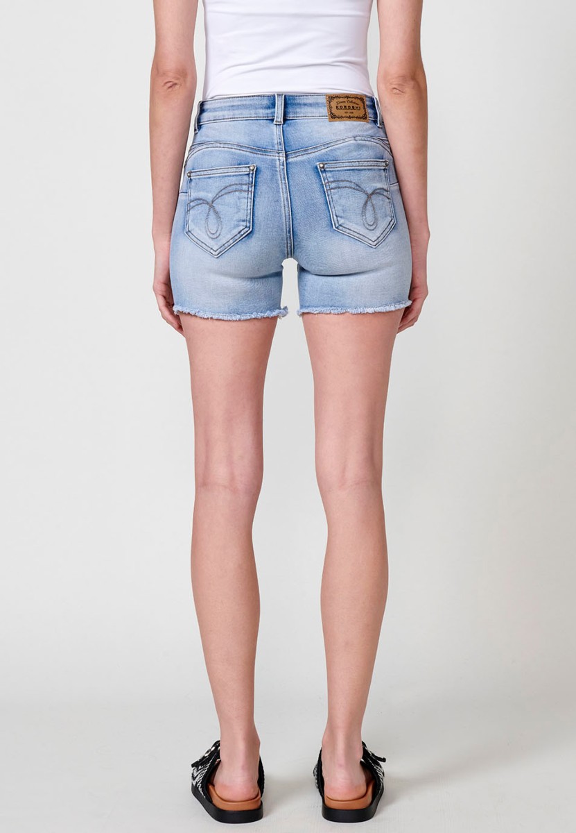 Jeans short elástico push up de tiro medio y cinco bolsillos con cierre y cremallera y botón metálico con detalle de brillos en bolsillos y bajo deshilachado para mujer de color azul claro