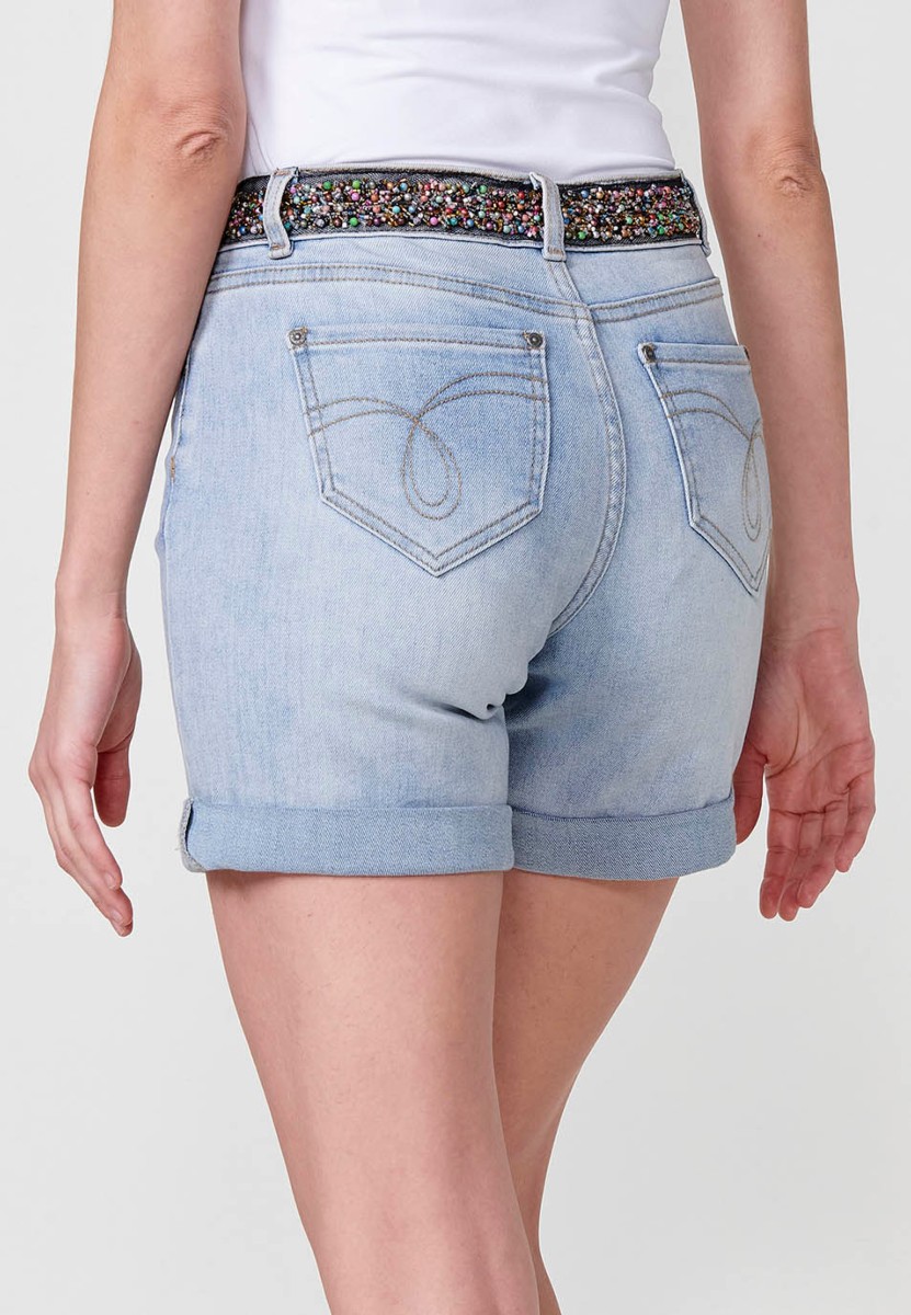 Jeans short elástico tiro medio y cinco bolsillos con abalorios de colores en cintura y cierre con cremallera y botón metálico con bajos con doble vuelta para mujer de color azil calaro