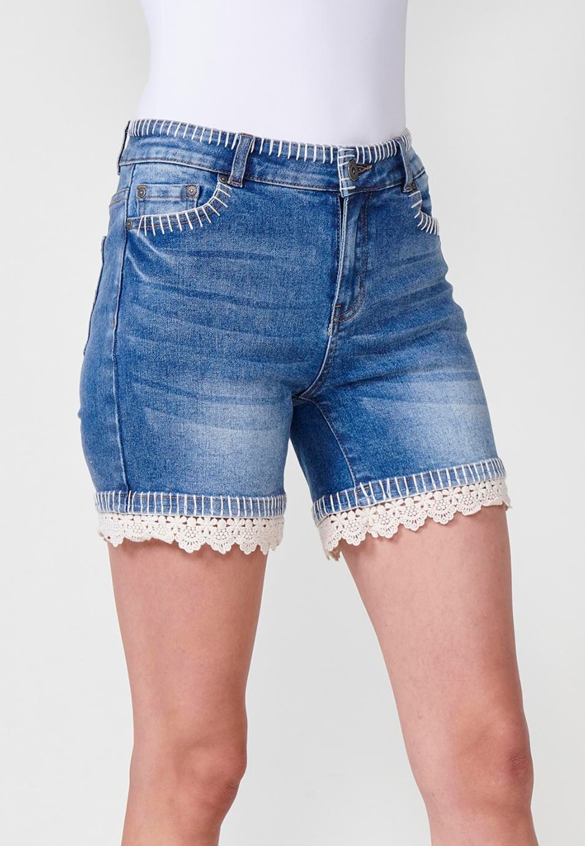 Jeans short elástico de tiro medio y cinco bolsillos con cierre con cremallera y botón metálico y detalle de pespuntes hechos a mano en bolsillos, cinturilla y bajo para mujer de color azul medio