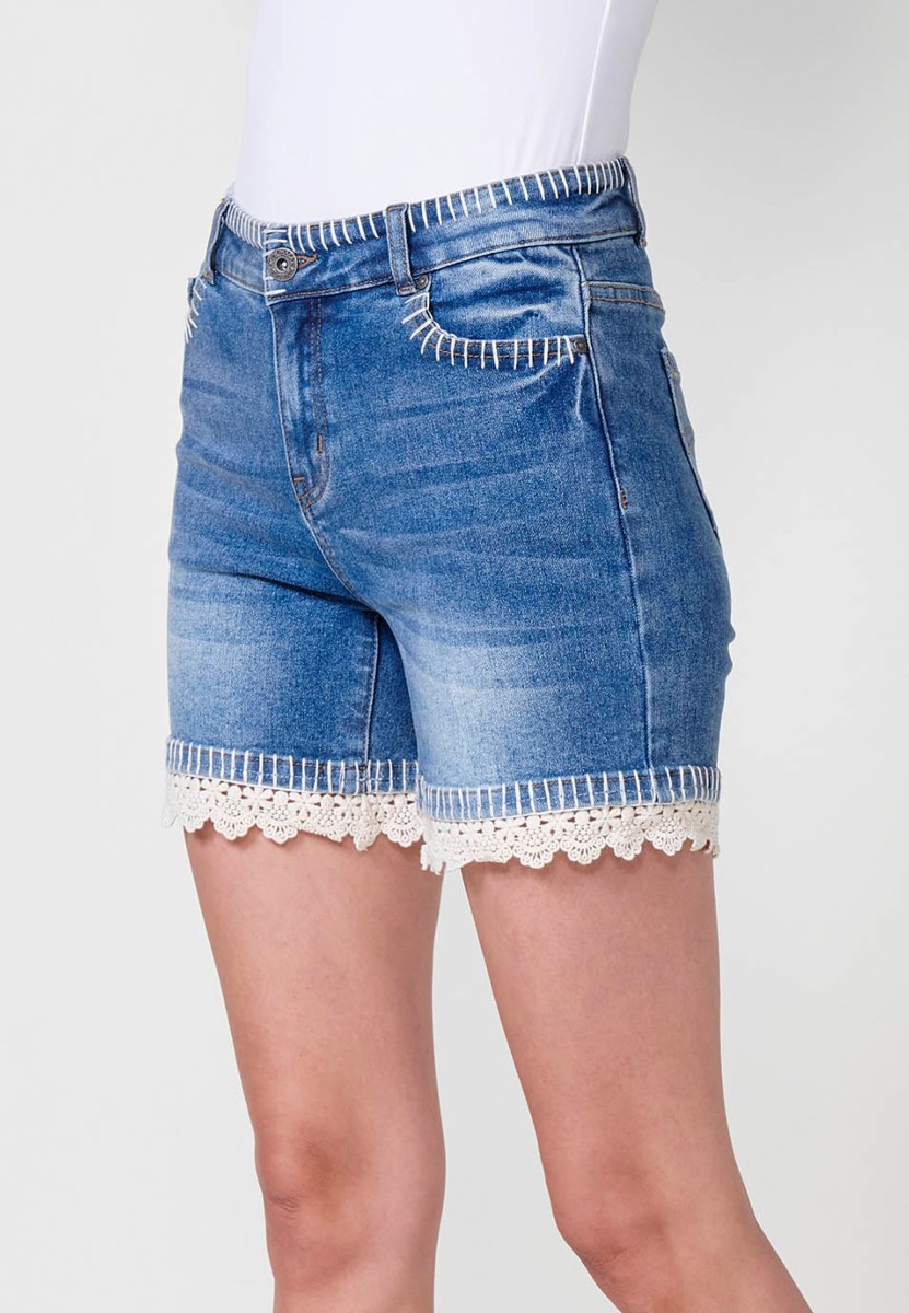 Jeans short elástico de tiro medio y cinco bolsillos con cierre con cremallera y botón metálico y detalle de pespuntes hechos a mano en bolsillos, cinturilla y bajo para mujer de color azul medio