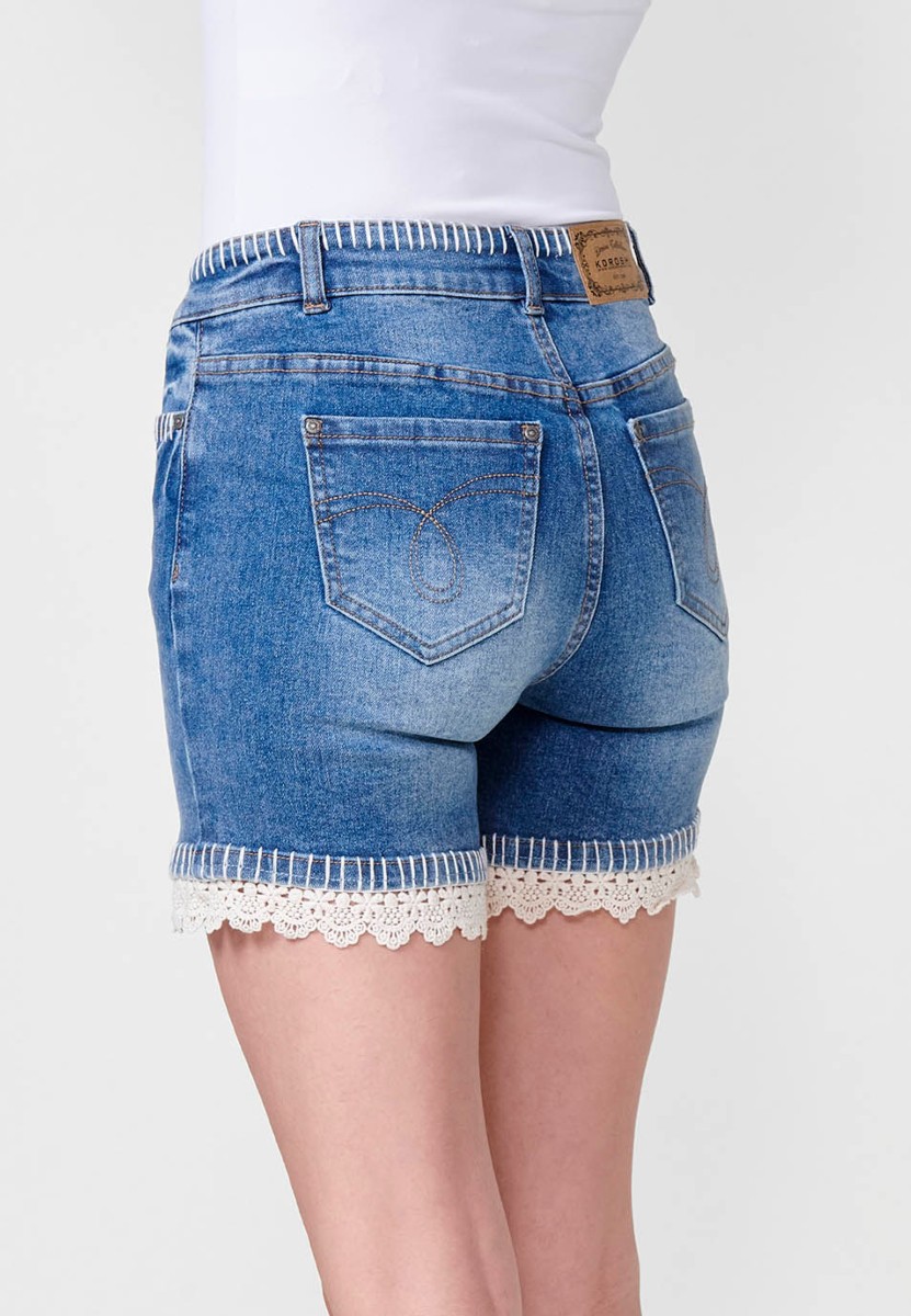 Jeans short elástico de tiro medio y cinco bolsillos con cierre con cremallera y botón metálico y detalle de pespuntes hechos a mano en bolsillos, cinturilla y bajo para mujer de color azul medio