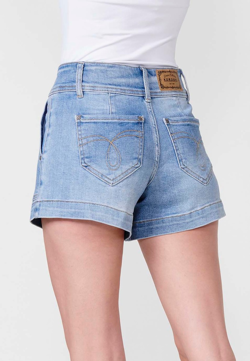 Short jean elásticocon bolsillos delanteros y traseros con cinturilla alta don doble botón metálico y cierre con cremallera con logo y brillos en bolsillo para mujer de color azul medio