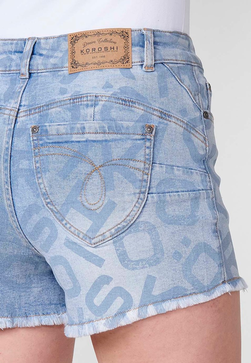 Short jean elástico de tiro medio y cinco bolsillos con cierre con cremallera y botón metálico y estampado Koröshi en todo el pantalón con bajo desilachado para mujer de color azul claro