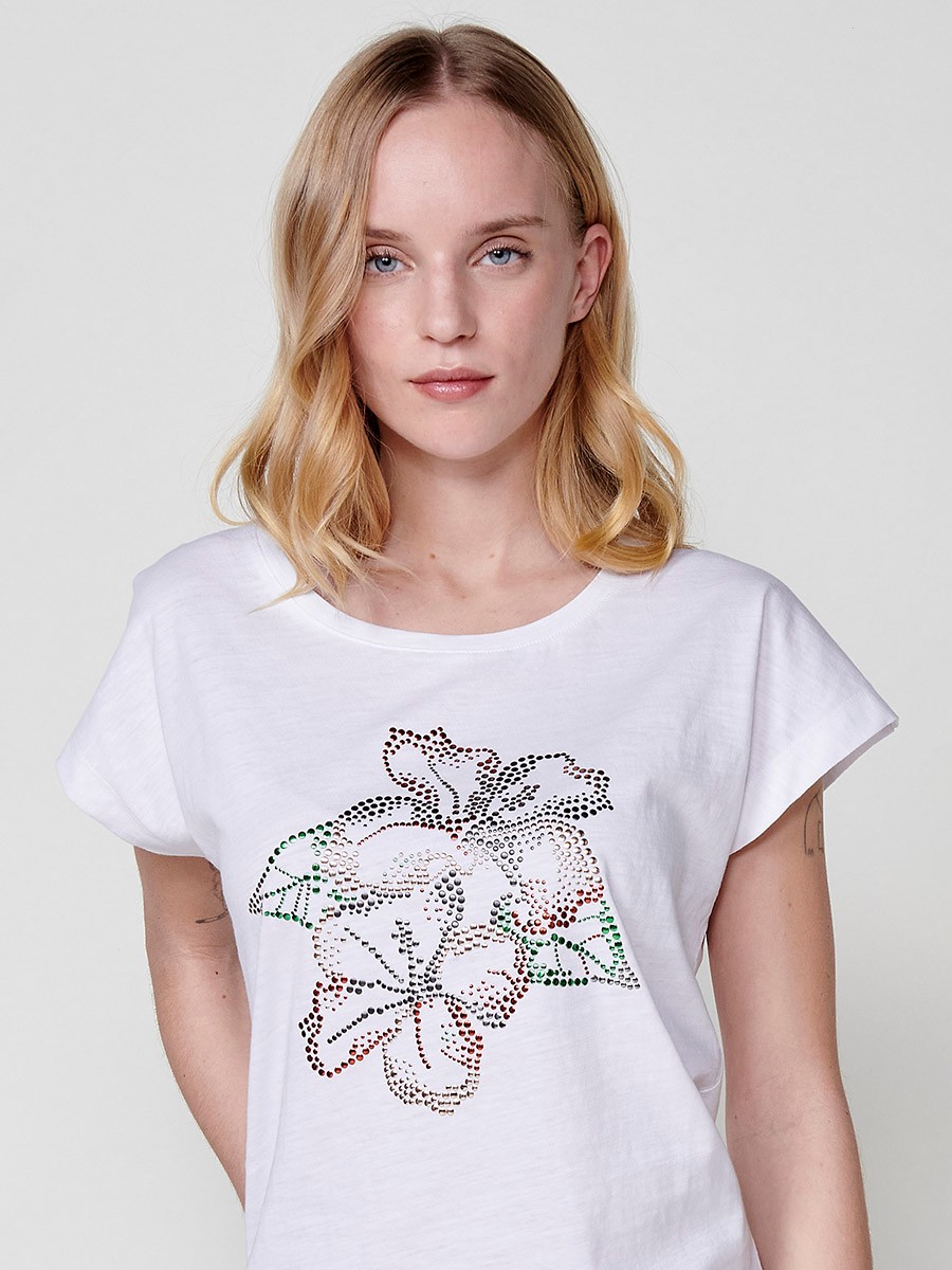 T-shirt blanc à manches courtes et col rond pour femme avec une fleur pailletée sur le devant et une plaque métallique avec le logo Koröshi sur le devant